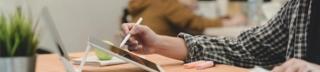 Person using a pen on a tablet on a modern desk